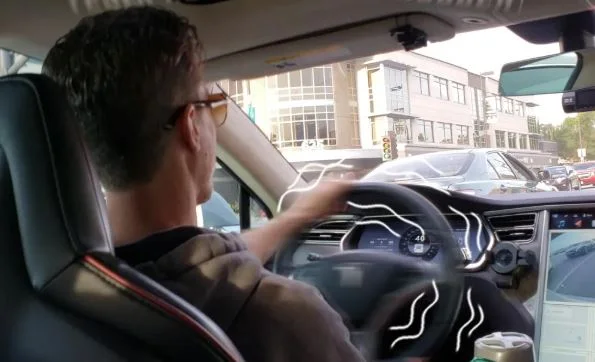 Driver gripping a steering wheel that shakes and vibrates while accelerating