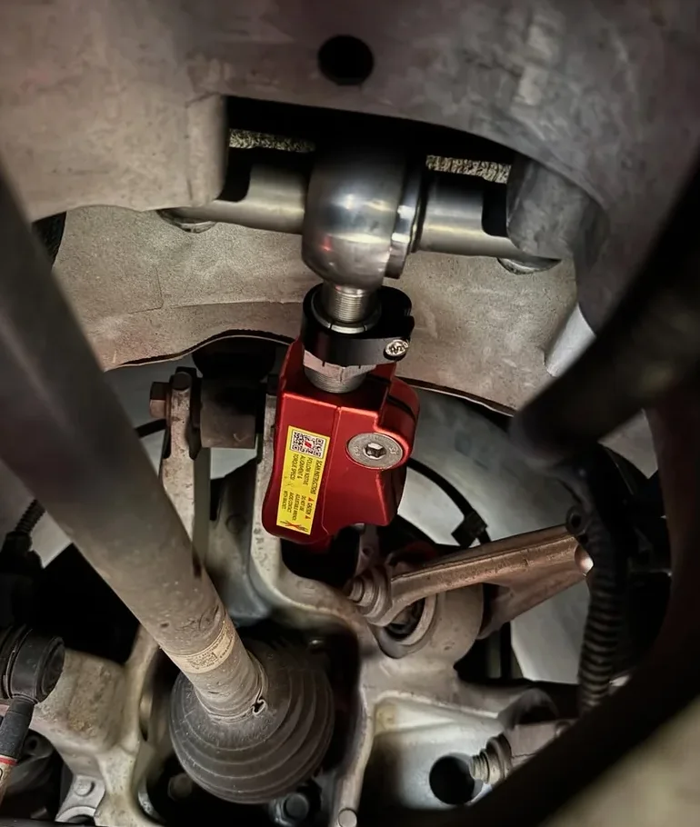 N2ITIVE adjustable rear control arm installed in the rear wheel well of a Tesla Model X