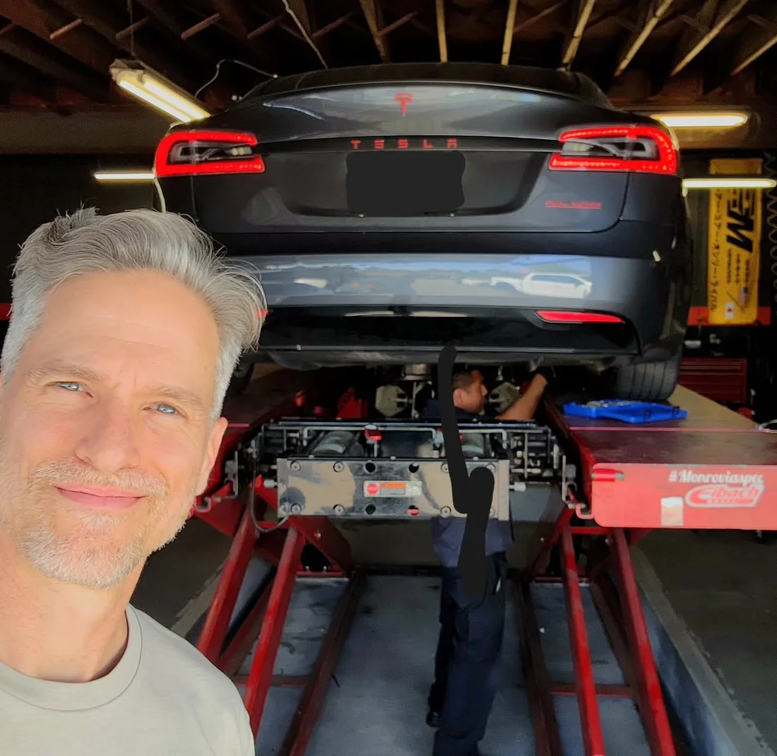 Owner at Monrovia Alignment with his Tesla Model S raised on the lift while the N2ITIVE kit is installed